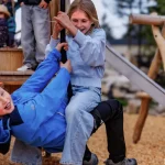 Zwei Kinder sitzen auf der Seilrutsche